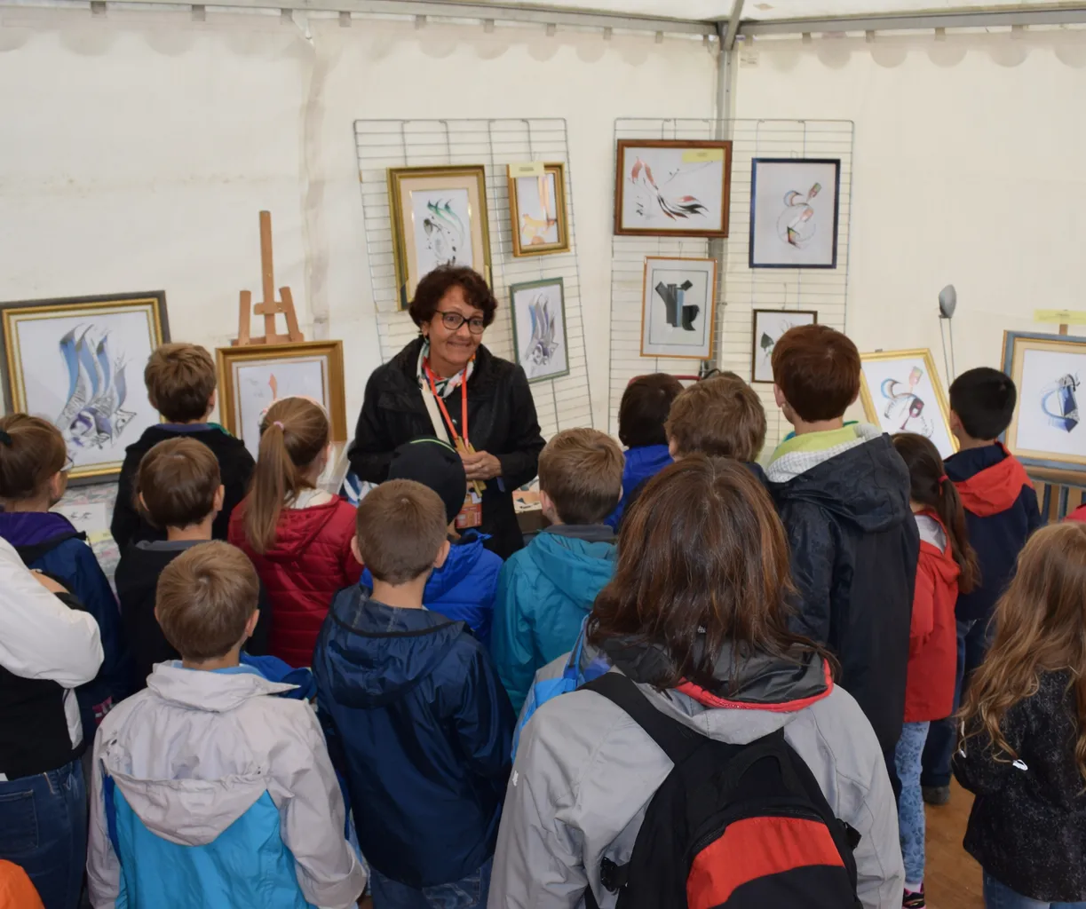 Zohra presenting Arabic calligraphy to a group of children during a workshop